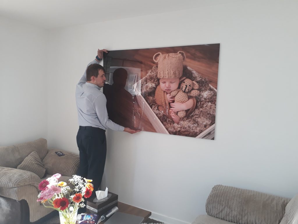 Simon hanging a large wall art piece