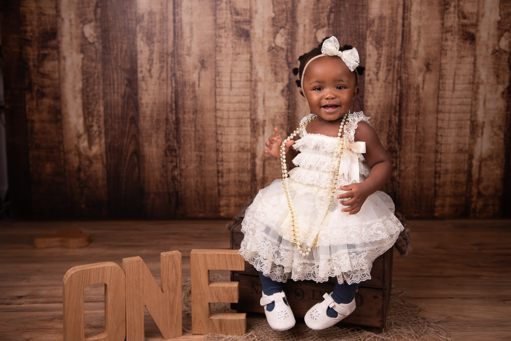 little girl in a white dress first birthday